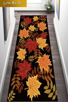 a black rug with autumn leaves on it