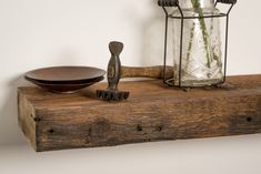 a wooden shelf with a glass jar, bowl and spoon on it next to a candle holder