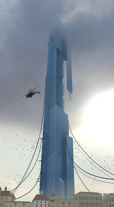 birds are flying in the air near a tall building that is being constructed into a skyscraper