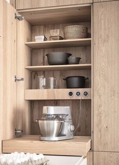 a kitchen with wooden cabinets and shelves filled with pots, pans and other cooking utensils