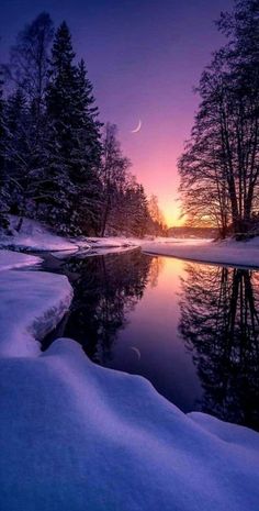 the sun is setting over a snowy river