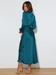 Make a statement in this FROM THE SOURCE High Neck Bridal Maxi Dress in an elegant teal! This stunning satin dress will make waves as you walk down the aisle and beyond. Dare to be bold and defy expectations with this daring wedding guest style dress. Stand out! Size Guide: Model is 5’7” tall, and has a 33.4” bust, 26.5” waist, & 34.6” hips. She is wearing a S / US 4 / AU 8. This dress is true to size. Material: 100% Polyester. Feature: High Neckline. Long Sleeve. Flowery Skirt. Elastic Waist. Maxi Length. Care Instructions: Machine wash / Cold hand wash Elegant Turquoise V-neck Maxi Dress, Solid Satin Maxi Dress For Wedding, Long Sleeve Turquoise Dresses For Wedding, Satin Midi Dress For Wedding, Solid Satin Midi Dress For Wedding, Wedding Midi Dress With Satin Finish, Green Satin Bridesmaid Midi Dress, Green Satin Midi Dress For Bridesmaids, Elegant Turquoise Maxi Dress For Party