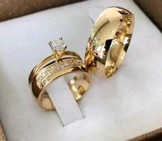 two gold wedding rings sitting in a box