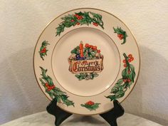 a christmas plate with holly and red berries on the rim is sitting on a marble table