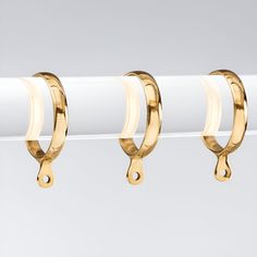 three pairs of gold hoop earrings hanging from a clothes line