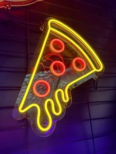 a neon sign with a slice of pizza on it's side hanging from the ceiling