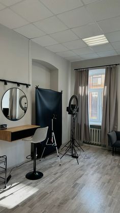 an empty room with chairs, lights and mirrors