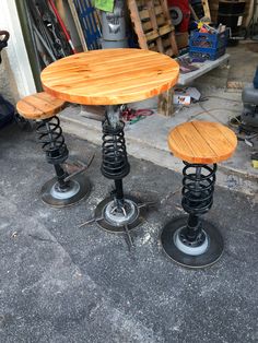 three wooden stools sitting next to each other in front of a garage door on the sidewalk