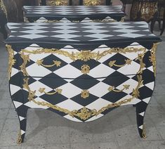 two black and white checkered tables with gold trimmings on the top, one is