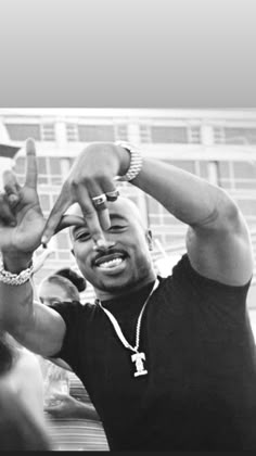 a black and white photo of a man making the v sign with his hands in front of him