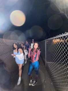 two girls standing in front of a fence