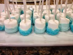 blue and white marshmallows are arranged on a platter with toothpicks