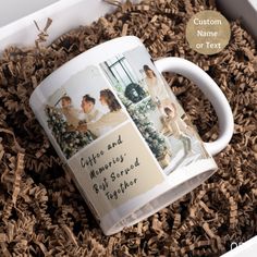 a coffee mug with two pictures on it in a box filled with wood shavings