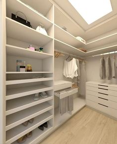 a walk in closet with white shelves and drawers