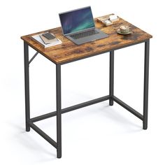 a laptop computer sitting on top of a wooden desk next to a book and cup