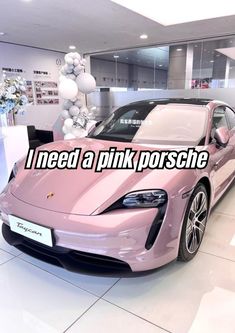 a pink sports car parked in a showroom