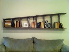 a couch sitting in front of a wall mounted book shelf filled with lots of books