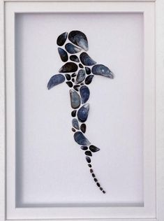 a sea turtle made out of seashells in a white frame