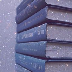 three books are stacked on top of each other in front of a wall with stars