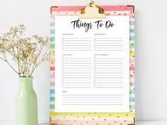 a clipboard with things to do list on it next to a vase filled with baby's breath flowers