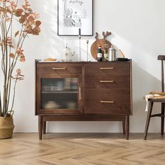 a wooden cabinet sitting next to a potted plant