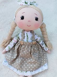 a doll with blonde hair wearing a brown dress and white polka dot print on it