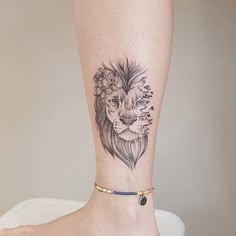 a woman's foot with a lion tattoo on the side of her leg,