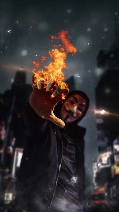 a man in a hoodie holding up his hand with fire coming out of it