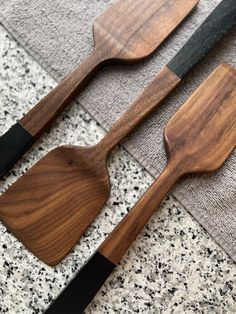 two wooden utensils are sitting on the floor