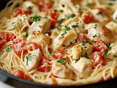 pasta with chicken, tomatoes and parsley in a skillet ready to be eaten