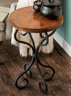 a table with a pot on top of it next to a chair and wall in the background