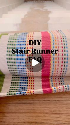 a roll of fabric sitting on top of a wooden table next to a mirror with the words diy stair runner fq