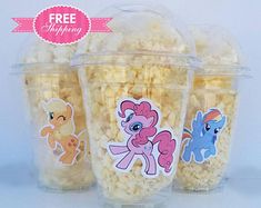 three plastic cups filled with popcorn and little pony stickers on them, sitting next to each other