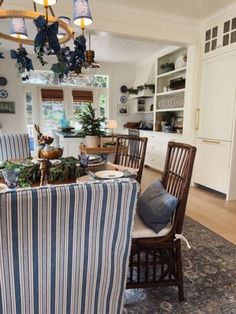 a dining room table with blue and white striped chairs