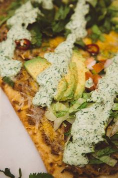 a pizza topped with cheese, lettuce and other toppings on top of it