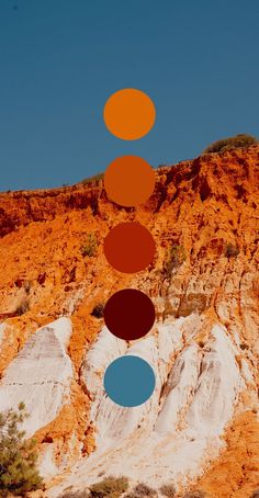 four circles are arranged in the shape of an orange and blue circle on top of a mountain