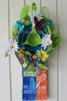 a bouquet of flowers hanging from the side of a white wall with words on it