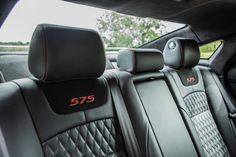 the interior of a car with black leather and red stitching