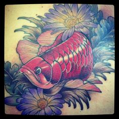 a tattoo with a fish and flowers on it