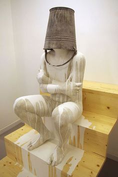 a white statue sitting on top of a wooden step