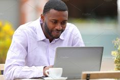 a man sitting at a table working on his laptop