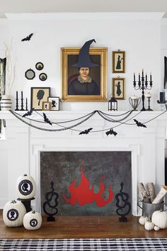 a fireplace decorated for halloween with black and white decorations on the mantel above it