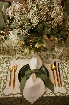 a table set with place settings and flowers