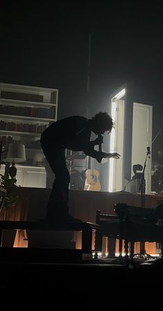 a man standing on top of a stage next to a piano