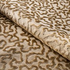 an upholstered fabric with brown and beige designs on it, as well as a white background