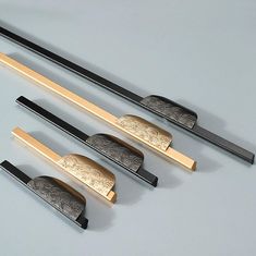 four chopsticks are lined up next to each other on a gray table top