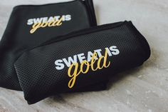 two black and gold sweats bags sitting on top of a marble counter next to each other