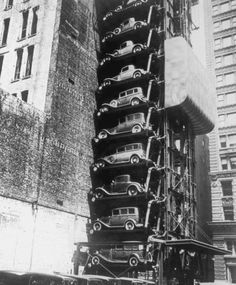 cars are stacked on top of each other in front of a tall building with many windows