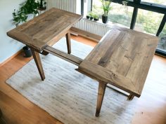 two wooden tables sitting next to each other on top of a white rug in front of a window