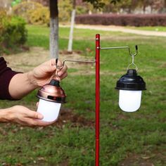 a person is holding a light in one hand and another on the other with a lamp attached to it